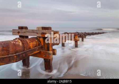 Tuyau d'écoulement vieux Cambois plage sur la côte de Northumberland, en tenant des déchets dans la mer du Nord. Banque D'Images