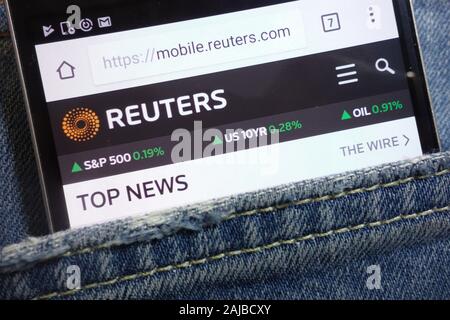 Site web de Reuters affiché sur smartphone caché dans la poche de jeans Banque D'Images