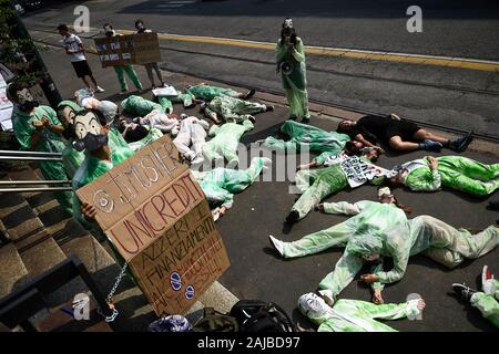 Turin, Italie - 19 juillet, 2019 : activistes du climat montrent qu'ils ils s'allongent sur le sol devant une banque Unicredit portant des masques inspirés par l'argent série Heist ('La casa de papel") diffusée par Netflix. Activistes du climat à partir de vendredi pour l'avenir et l'extinction des groupes de rébellion protester contre les investissements des banques dans les combustibles fossiles. Credit : Nicolò Campo/Alamy Live News Banque D'Images