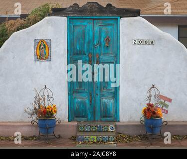 Vieille porte en bois texturé turquoise avec deux pots de fleur dans le quartier historique de Mesilla, Nouveau Mexique près de Las Cruces Banque D'Images