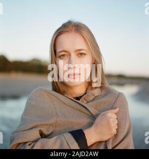 Belle femme debout dans des vêtements près de la mer Banque D'Images