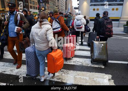 Les touristes avec des valises et bagages sur une rue à Manhattan, New York, NY Banque D'Images