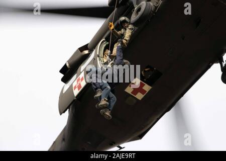 L'Armée de l'Iowa (Garde nationale) avec les soldats de IANG 2-211ème bataillon de l'aviation d'appui général tirer les membres du Groupe de travail de l'Iowa dans un UH-60 Black Hawk lors des opérations de sauvetage sur le toit et d'un palan à Camp Dodge Centre mixte le 20 novembre 2019. La formation permettra d'assurer les membres de l'équipe spéciale et le reste prêt à répondre IANG aux catastrophes naturelles. (U.S. La Garde nationale de l'armée photo par le Sgt. Tawny Schmit) Banque D'Images