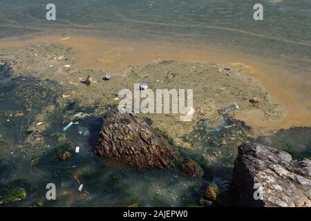 Ondulation de la houle surf mauvaises ordures à la côte rocheuse plage polluantes et menant à la Banque D'Images