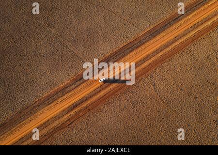 Voiture sur une piste désertique à distance dans l'Outback australien. Banque D'Images