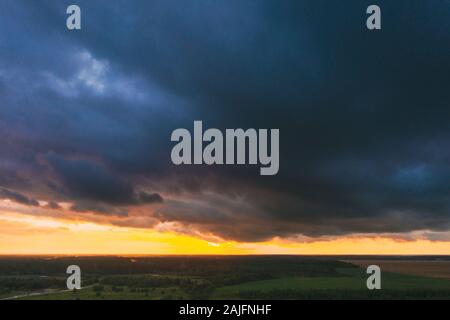 Vue aérienne de la forêt verte au-dessus de ciel coucher de soleil Paysage en soirée. Vue de dessus de l'attitude en été le lever du soleil. Des nuages de pluie. Banque D'Images
