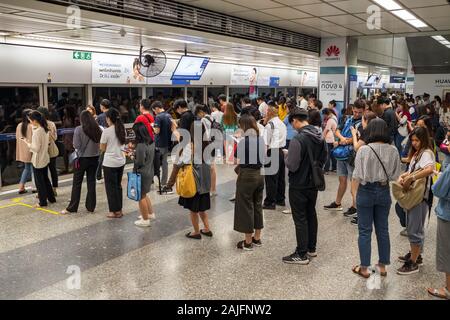 Personnes debout dans les lignes en attente de train aérien BTS à Bangkok en Thaïlande Banque D'Images