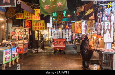 Xi'an, Chine : boutiques et enseignes lumineuses la nuit dans une route traditionnelle du quartier de mousseline à Xian (xi). Scène urbaine, l'alimentation de rue Banque D'Images