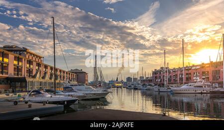 Genova, Liguria, Italie : vue du coucher du vieux port (Porto Antico), voiliers amarrés à quai à proximité aquarium, réflexions sur l'eau, soleil Banque D'Images