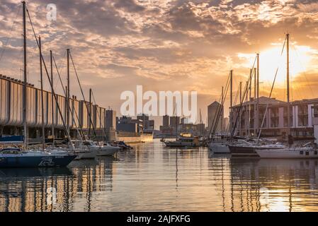 Genova, Liguria, Italie : vue du coucher du vieux port (Porto Antico), voiliers amarrés à quai à proximité aquarium, réflexions sur l'eau, soleil Banque D'Images