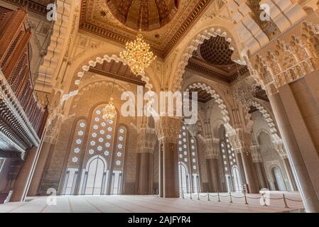 Casablanca, Maroc : l'intérieur (salle de prière) de la Mosquée Hassan II avec des colonnes, des arches et des lustres en verre. L'architecture islamique Banque D'Images