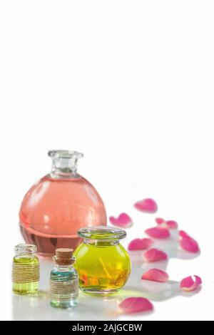 Des pétales de rose avec aromathérapie huiles essentielles le flacon en verre isolated over white , fond, copy-space Banque D'Images