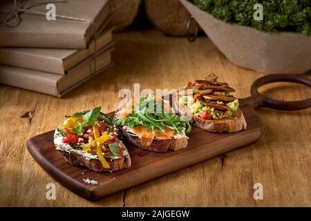 Bruschetta italienne ou un sandwich sur un plateau et fond de bois d'été, des plats de saison. Banque D'Images