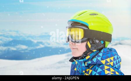 Portrait d'un petit garçon en costume de skieurs, halmet et lunettes de ski montagne. À côté de l'espace de copie Banque D'Images