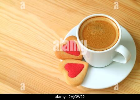 Tasse de café et une paire de cookies en forme de coeur sur table en bois avec copie espace Banque D'Images