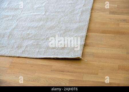 Close up de tapis froissé sur plancher plancher en bois. Banque D'Images