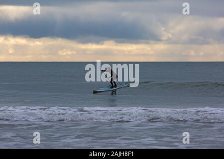 Bournemouth, Dorset UK. 4e janvier 2020. Météo France : lone paddle boarder, paddleboarder, à la plage de Bournemouth sur un jour sec avec le soleil essaie de percer. Credit : Carolyn Jenkins/Alamy Live News Banque D'Images