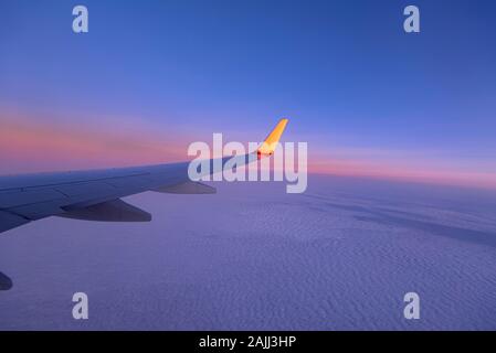 Coucher de soleil sur Ciel et aile d'avion, vue depuis la fenêtre de l'avion, en arrière-plan Banque D'Images