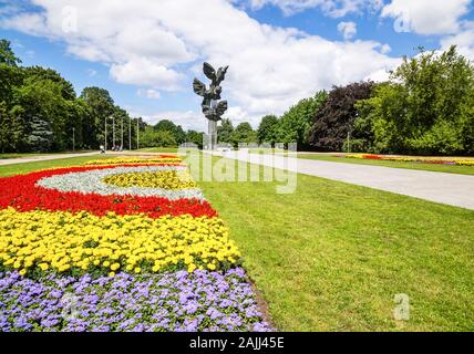 Szczecin, Pologne, juin 2016 Monument de l'Acte de polonais dans la forme de trois Eagles à un parc Kasprowicz avec des rangées de fleurs colorées Banque D'Images