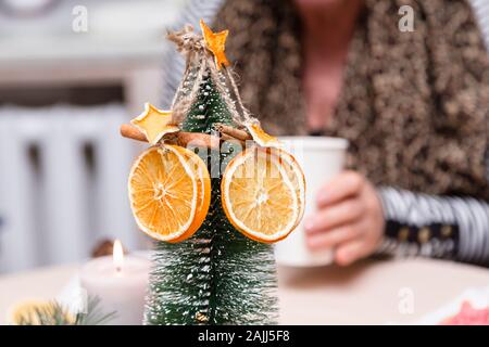 Orange séchée, stars de la mandarine et la cannelle décoration accrochée à un arbre de Noël. arrière-plan flou. Banque D'Images