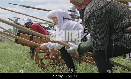 Chevaliers en offensive. La préparation de l'attaque des Guerriers et le artilleryist tirer du canon. Banque D'Images