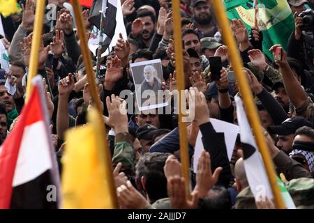 Partisan de l'Iran chiite irakien soutenu par les groupes armés des forces de mobilisation populaire porte la photo de tué Abu Mahdi al-Muhandis lors d'un cortège funéraire dans le centre de Bagdad, l'Iraq le Samedi, Janvier 4, 2020. Des milliers d'Irakiens en scandant "Mort à l'Amérique" s'est joint à la procession funéraire pour le commandant militaire iranien Qasem Soleimani et Muhandis, tous deux tués dans une frappe aérienne américaine. En tout, 10 personnes -- cinq irakiens et cinq Iraniens -- ont été tués vendredi matin en grève aux États-Unis sur leur cortège de juste à l'extérieur de l'aéroport de Bagdad. Photo par Ibrahim Jassam /UPI Banque D'Images