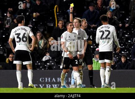 Fulham Anthony Knockaert (centre) est montré un carton jaune par l'arbitre Craig Pawson au cours de la FA Cup troisième ronde match à Craven Cottage, à Londres. Banque D'Images