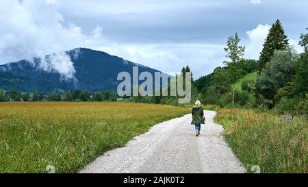 Le randonneur blond fait des promenades le long du sentier dans les contreforts pittoresques des Alpes bavaroises, près de la célèbre ville de Passion Play d'Oberammergau, en Allemagne Banque D'Images