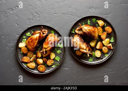 Les carcasses de cailles grillées savoureuses avec des pommes sur fond noir en noir. Haut de la vue, télévision lay Banque D'Images