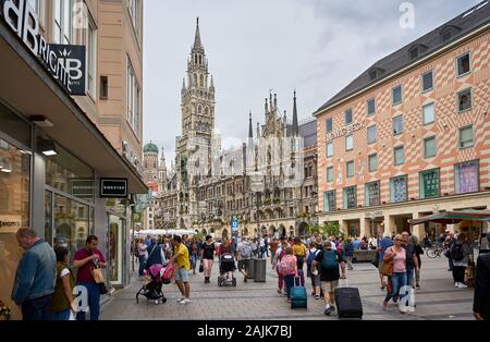 Des foules de shopping dans le centre-ville de Munich, avec le célèbre Rathaus ou l'hôtel de ville en arrière-plan. Banque D'Images