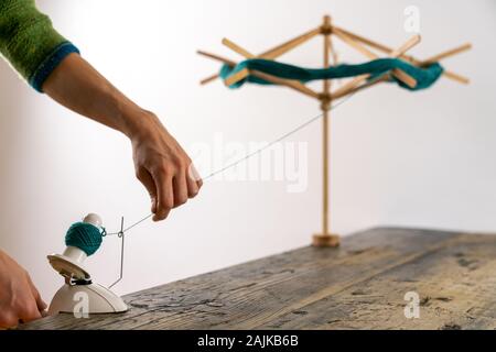 Vue d'une mise au point sélective caucasian woman travaillant un rouleau de laine à tricoter pour se préparer pour le tricotage de thread Banque D'Images