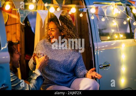 Autre mode de voyage et de célébration concept avec deux ou trois personnes gaies adultes femmes heureux de célébrer ensemble dans un parti et le camping-vintage ligh Banque D'Images