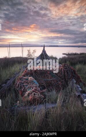 vieux bateau abandonné couvert de filets de pêche Banque D'Images