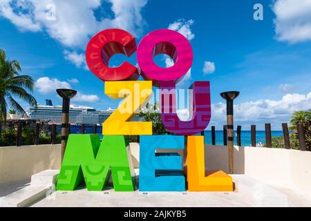 Signe coloré le long de la rue à Cozumel, Mexique. Bateau de croisière sur l'arrière-plan. Banque D'Images