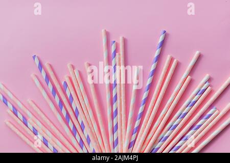 Pailles boire à rayures de couleurs différentes dans la rangée isolé sur fond jaune. Le minimalisme concept. Pop art style. Mise à plat avec les pailles utilisées pour drinki Banque D'Images