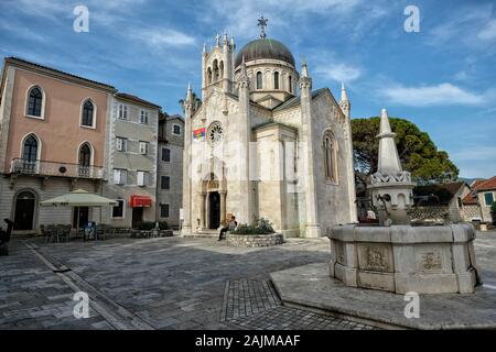 Herceg Novi, Monténégro - juin 2019: Église de St Michael Archange avec l'ancienne fontaine en pierre au premier plan le 22 juin 2019 à Herceg Novi Banque D'Images