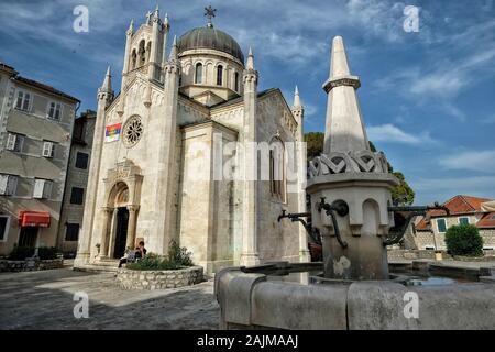 Herceg Novi, Monténégro - juin 2019: Église de St Michael Archange avec l'ancienne fontaine en pierre au premier plan le 22 juin 2019 à Herceg Novi Banque D'Images