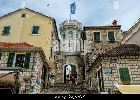 Herceg Novi, Monténégro - juin 2019: Les touristes dans la vieille porte de la ville avec la petite tour d'horloge entourée de maisons anciennes le 22 juin 2019 au Monténégro Banque D'Images