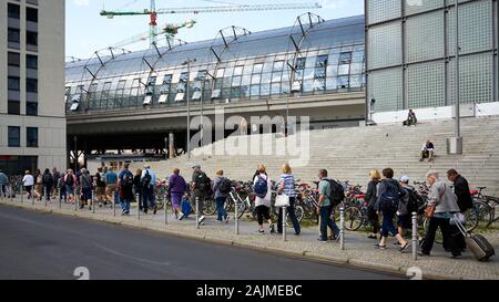 Rue franc tiré d'une longue lignée de voyageur marche sur le trottoir à l'extérieur de la gare principale de Berlin des valises ou sacs à dos tirez la languette. Banque D'Images