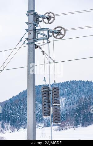 Les détails du système d'électrification ferroviaire. L'alimentation électrique de l'acier, de lignes aériennes avec des contrepoids en béton pylône suspendu à un système de poulies Banque D'Images