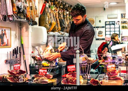 Jambon Ibérique de coupe homme à l'étal dans Mercat de l'Olivar, Palma, Majorque, Espagne Banque D'Images