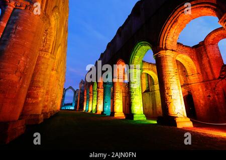 L'abbaye de Fountains Nef lors d'une fête de Noël illuminations multicolores Banque D'Images