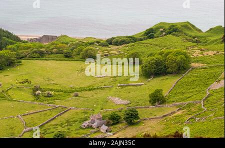 Une ferme et une cour de ferme isolée et partiellement ruinée est nichée dans une vallée éloignée sur la côte de la péninsule de Llyn, dans le nord du pays de Galles. Banque D'Images