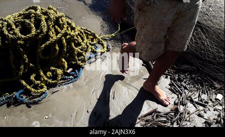 Tucacas, Falcon, le Venezuela. 4 janvier, 2020. 04 janvier, 2019. Un homme wlh entre le rex terminer le travail de pêcheurs sur la rive de la plage dans la ville de Tucacas, Falcon de l'état. Le Venezuela. photo : Juan Carlos Hernandez Crédit : Juan Carlos Hernandez/ZUMA/Alamy Fil Live News Banque D'Images