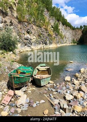 Bateau abandonné dans une carrière inondée avec cristal bleu de l'eau. Site de plongée avec de l'eau propre et bleu pour les plongeurs peu lavabo Bateau abandonné dans le lac. Floreffe, Belgique. Banque D'Images