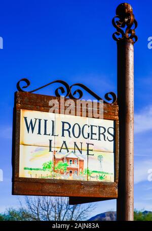 Close up de tuiles picturale représentant Garrett chambre encadrée dans un support d'enseigne en métal ouvragé lecture Will Rogers Lane, contre un ciel bleu dans Tubac, AZ Banque D'Images