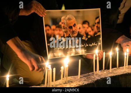 Pékin, l'Iran. 3 janvier, 2020. Les gens allument des bougies à côté d'une affiche de haut commandant iranien Qasem Soleimani lors d'une cérémonie de deuil à Téhéran, Iran, 3 janvier 2020. Une attaque près de l'aéroport international de Bagdad le vendredi a tué Qasem Soleimani, et Abu Mahdi al-Muhamdis, le sous-top chef de l'Hashd forces paramilitaires Shaabi. Credit : Ahmad Halabisaz/Xinhua/Alamy Live News Banque D'Images