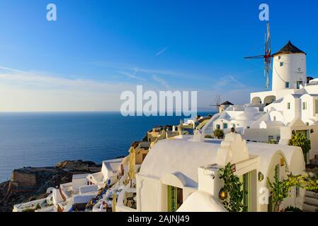 Moulin blanc traditionnel et immeubles faisant face à la mer Egée à Oia, Santorin, Grèce Banque D'Images