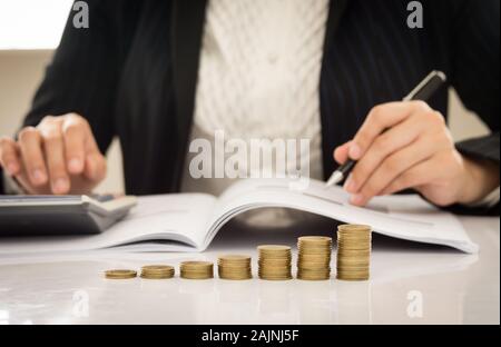 La croissance de l'entreprise concepts. close-up des pièces d'or avec des gens d'affaires travailler. Banque D'Images