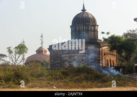 Le magnifique temple hindou ancien de Radha Shyam vu de la rue. La fumée s'élève du plastique brûlant à l'extérieur de ses murs. Banque D'Images